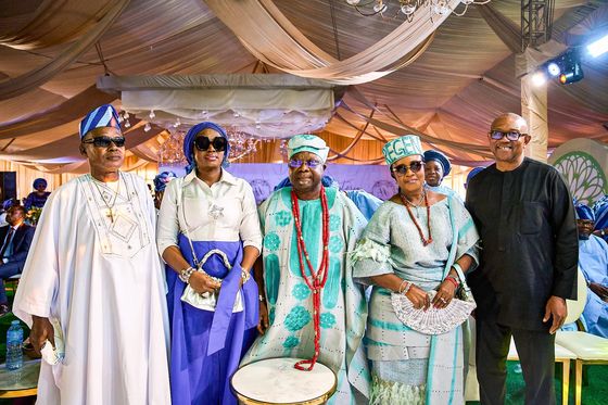 Peter Obi standing with a family in Yoruba ceremonial dress beside a talking drum