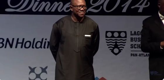 Peter Obi standing on stage at the Lagos Business School President's Dinner while his citation is read