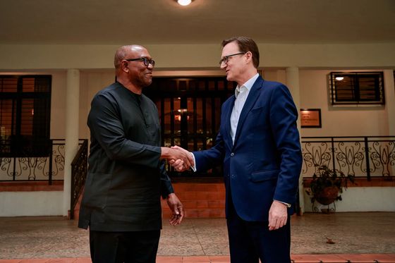 Peter Obi shaking hands with a visitor on a tiled veranda